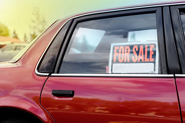 An old red car with a banner "For sale"